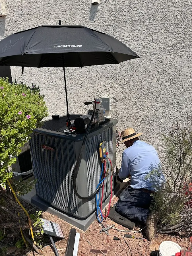 HVAC technician performing outdoor AC maintenance in Elfers