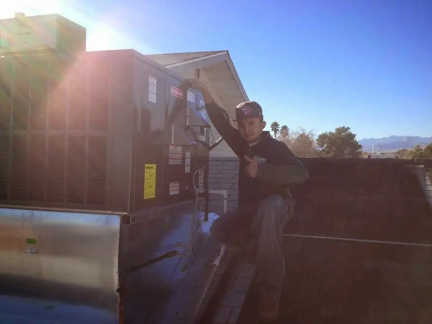HVAC technician performing Boiler Repair on a rooftop unit in Elfers